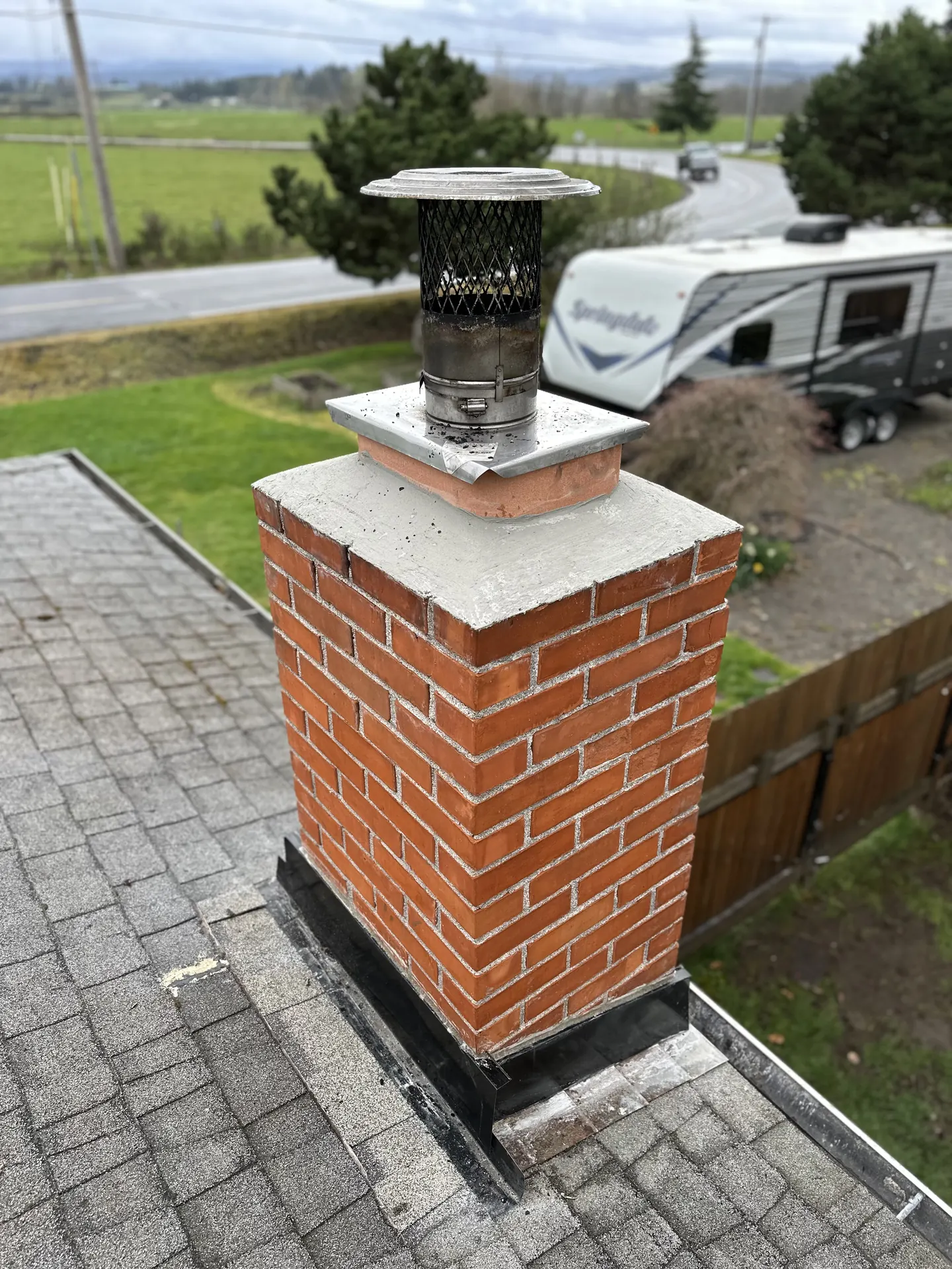 A repointed chimney crown with fresh mortar joints and new step flashing by First Rate Chimney