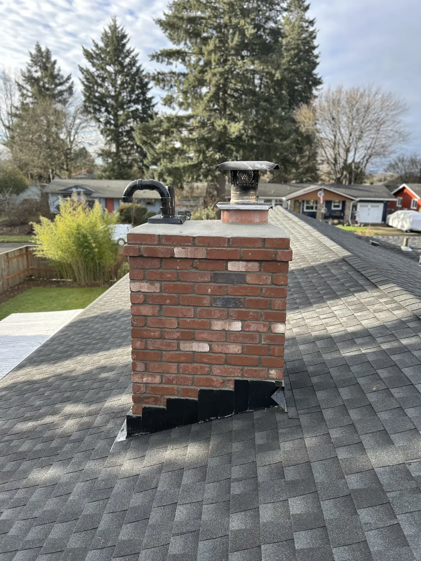 A First Rate Chimney rooftop documentation photo of a brick chimney with a pellet stove vent
